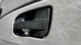 Close-up of a black door handle on a textured gray panel of a 2019 International 4300 truck