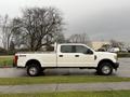 A white 2017 Ford F-350 Super Duty truck with a crew cab and a long bed parked on a grassy area