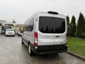 A 2019 Ford Transit van with a silver exterior is shown from the rear with tinted windows and a high roof design