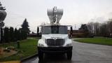 A white 2005 International 4300 bucket truck with an elevated boom positioned at the top ready for use