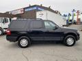 A black 2017 Ford Expedition parked with a side view showcasing its large body and steel wheels