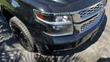 A 2018 Chevrolet Tahoe with a sleek black exterior and chrome grille featuring bright headlights and black wheels