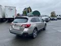 A silver 2019 Subaru Outback parked with its rear view visible showing a roof rack and a hatchback design