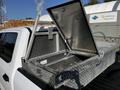 A metallic toolbox with a hinged lid on the bed of a 2017 Ford F-150 showing smoke venting from a pipe attached to the toolbox