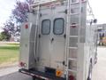A silver 2007 Morgan Olson Workhorse W42 vehicle featuring a rear door with mesh windows a ladder on the side and warning lights