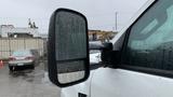 A 2021 International CV515 truck with a large side mirror showing raindrops on the glass