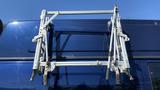 A silver folding ladder rack mounted on the roof of a blue 2013 Ford Econoline