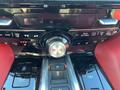 Dashboard controls of a 2023 Acura MDX featuring a central rotary knob and several buttons for vehicle settings and climate control