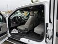 Interior view of a 2018 Ford F-150 showing seats dashboard and steering wheel in a light-colored upholstery with a spacious cabin design