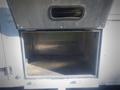 A metal storage compartment door of a 2006 Freightliner FS65 showing an empty interior with metallic walls and no contents inside