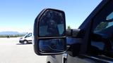 Side mirror of a 2017 Ford F-350 SD showing a reflective surface with a clear view of nearby vehicles and a partial view of the driver