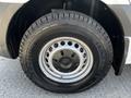 A close-up view of a tire on a 2022 Mercedes-Benz Sprinter featuring a silver wheel rim with the Mercedes-Benz logo and an all-terrain tread pattern
