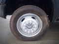 A close-up of a tire and wheel from a 2008 Ford F-550 showing the wheel's silver rim and lug nuts with a rugged tire tread