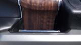 A 2017 Ford F-350 SD center console with a wood grain finish and chrome accents