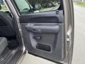 A close-up view of the interior door panel of a 2013 Chevrolet Silverado Hybrid featuring a handle and a storage compartment