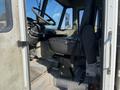 Interior view of a 2010 Freightliner MT45 garbage truck showing the driver's seat dashboard and steering wheel