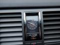 A close-up of a Cadillac dashboard clock featuring a black face and silver trim located in a luxury vehicle's panel