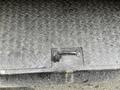 A close-up of a textured metal surface with a small handle embedded in it on a vehicle body