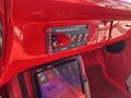 Dashboard of a 1962 Ford F-100 featuring a red ignition switch panel with multiple toggle switches and a digital screen displaying the time