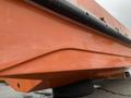 A bright orange 2008 Fassmer 20 Foot Fast Rescue boat with a sleek hull and rubber bumpers is positioned on a tire with wooden supports underneath