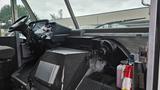 Interior of a 2006 Ford Econoline showing the driver's seat steering wheel dashboard and various controls including a fire extinguisher and additional equipment