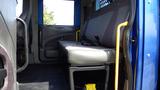 Interior view of a 2012 International DuraStar 4300 showing a single bench seat beside a section of the cabin wall and floor with safety harnesses and some seating details