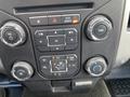 Controls and buttons of a 2013 Ford F-150 dashboard with knobs for volume air conditioning and tuning