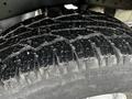 Close-up of a heavily treaded tire from a 2011 Ford F-250 SD showcasing deep grooves and a rugged design for off-road capability