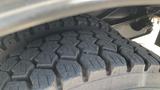 Close-up of a tire tread on a 2011 Ford F-450 SD showcasing the deep grooves and rugged design of the tire