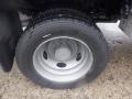 Close-up of a tire and wheel of a 2009 Ford F-450 SD featuring a silver aluminum rim and deep-treaded black tire