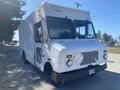 A 2008 Ford Econoline cargo van with a white exterior and a boxy shape featuring large windows and a front grill design