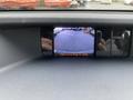 A 2013 Toyota Sienna displaying a rearview camera image on the dashboard screen with a message to check surroundings for safety