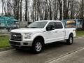 A white 2017 Ford F-150 pickup truck with a chrome grille and shiny wheels parked on a street