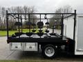 A 2005 Freightliner M2 106 flatbed with a black frame and circular fixtures mounted on the sides