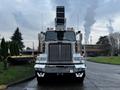 A 2011 Western Star Trucks 4900 with a shiny metallic body and prominent front grille featuring vertical stripes headlights and a large air intake on the roof