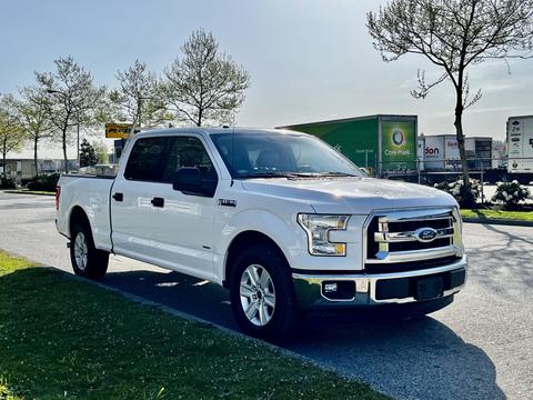 A 2017 Ford F-150 in white color parked on a street with a large cab and chrome accents on the front grille and wheels