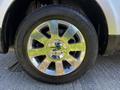 Close-up of a silver alloy wheel from a 2013 Lincoln MKT with a shiny center cap and a black tire