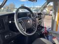 Interior view of a 2018 Chevrolet Express with a black steering wheel dashboard and control panel visible