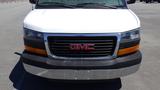 A white 2012 GMC Savana with a black grille and red GMC emblem is shown from the front