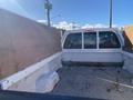 Interior of a 2000 Ford F-350 SD truck bed with wooden sides and a cab cover visible in the foreground