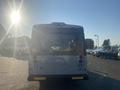 A white 2017 Chevrolet Express van viewed from the rear with a roof-mounted air conditioning unit and taillights visible