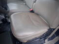 A beige leather seat of a 2008 Ford F-550 with seatbelt clips visible on either side