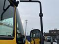 A yellow 2007 International 4300 truck with a prominent side mirror and a visible door panel