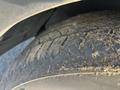 Close-up of a worn tire from a 2012 Kia Sportage showing visible tread wear and dirt buildup on the surface