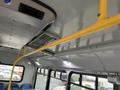 Interior view of a 2017 Chevrolet Express with a yellow grab bar and overhead ventilation system featuring lights and blue passenger seats in the foreground