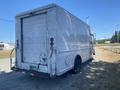 A white 2008 Ford Econoline van with a closed rear door and visible taillights parked on a gravel surface