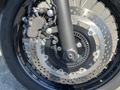 A close-up of a 2019 Kawasaki W800 CAFÉ front wheel with a disc brake system featuring a caliper and stainless steel spokes