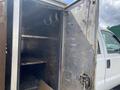An open stainless steel truck body with shelves and metal hooks inside mounted on a 2010 Ford F-550