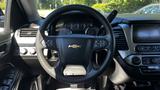 A 2018 Chevrolet Tahoe steering wheel with a central Chevrolet logo and various control buttons along with the dashboard featuring gauges and infotainment display