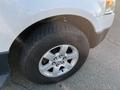 A 2013 Ford Expedition with a close-up view of the front tire and wheel showcasing a silver alloy rim and a rugged tire tread